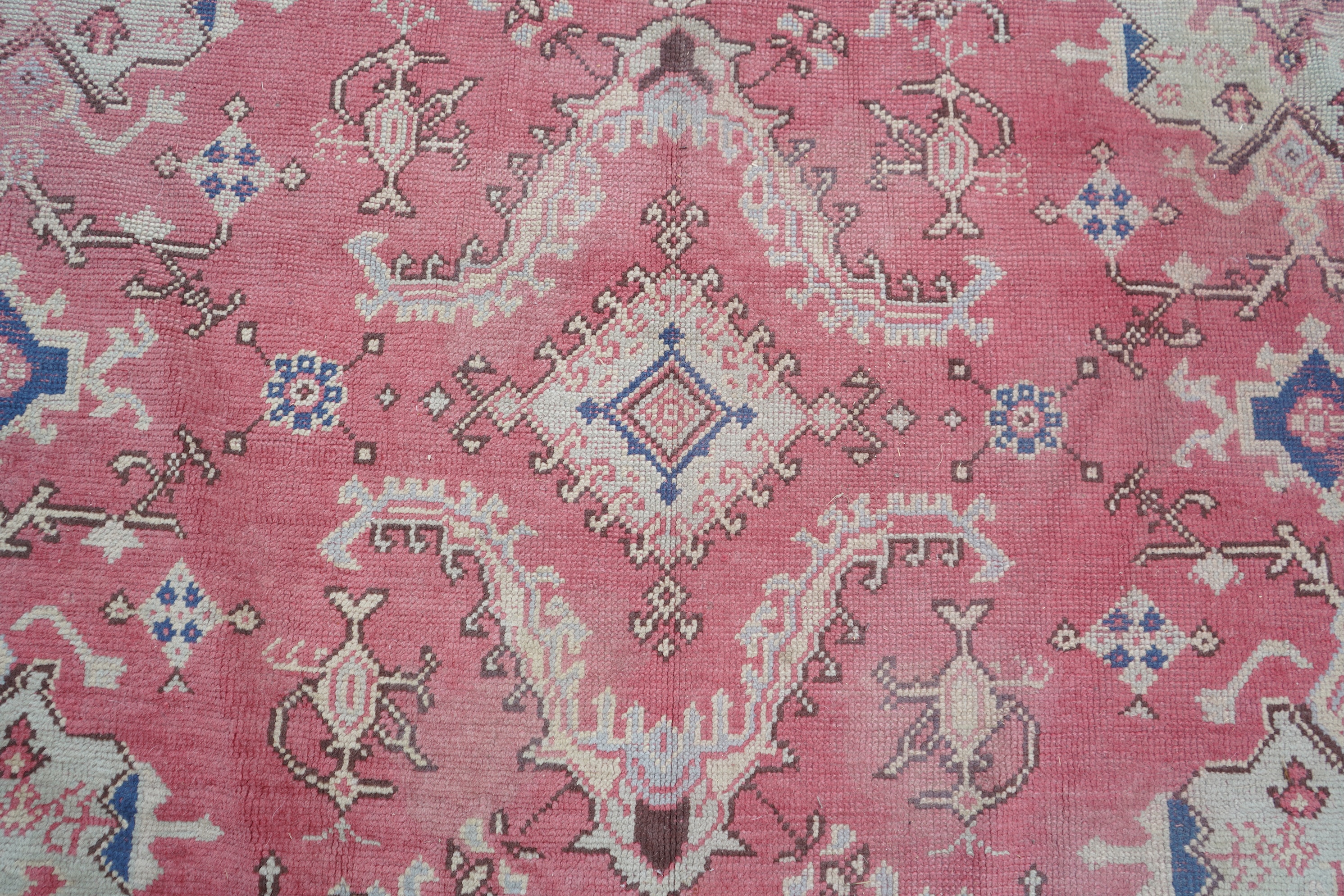 A large Turkish faded red ground carpet